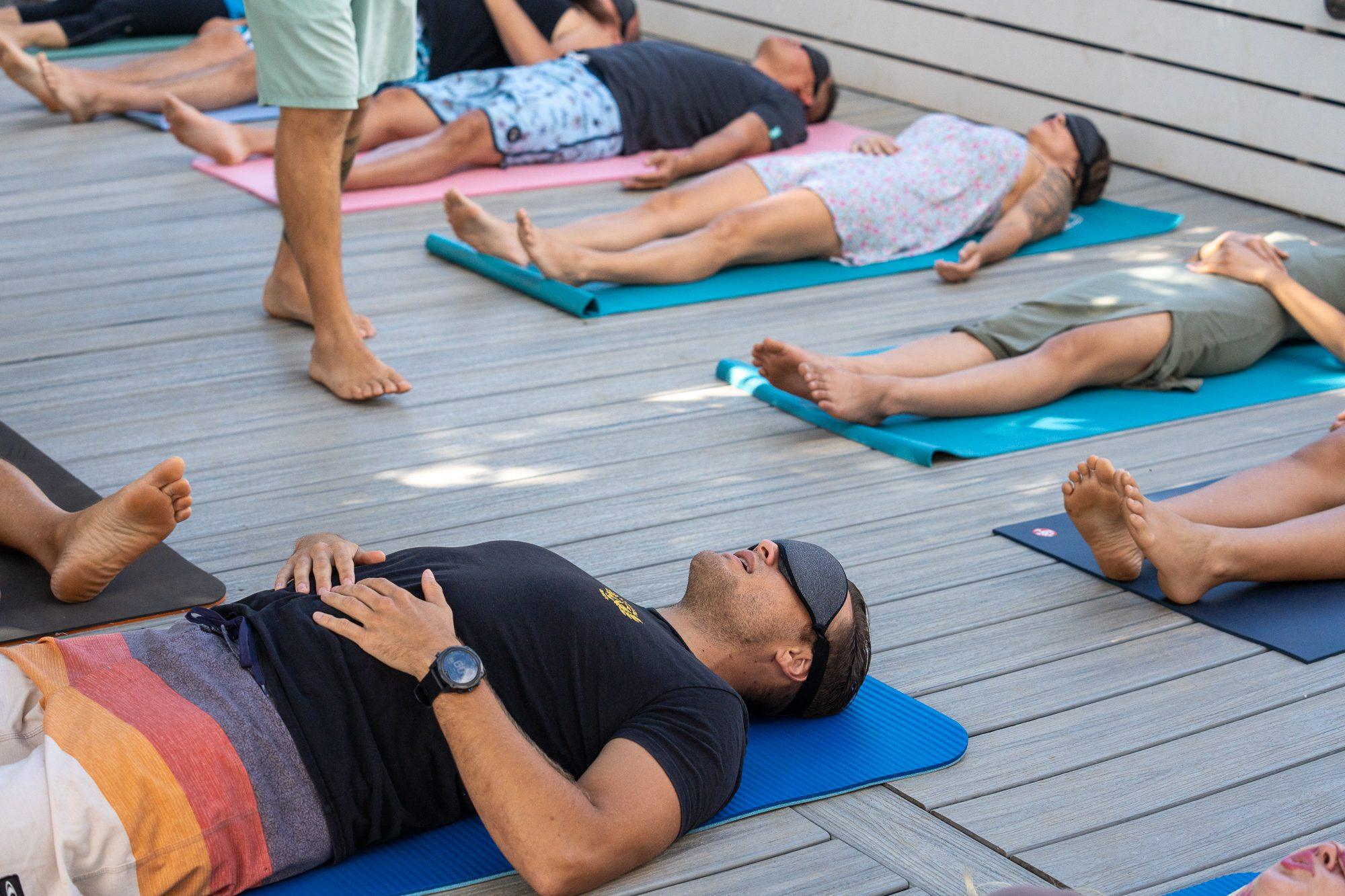 Top-down view of practitioners on yoga mats during a breathwork session