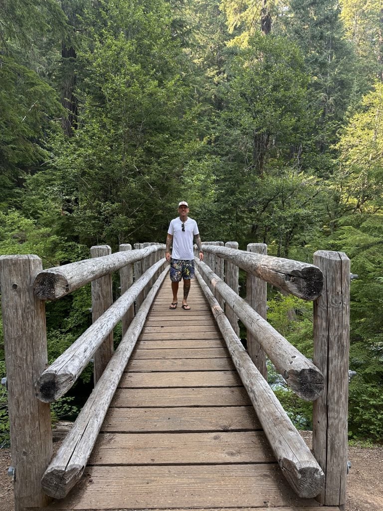 A participant on a forest footbridge during a guided hike